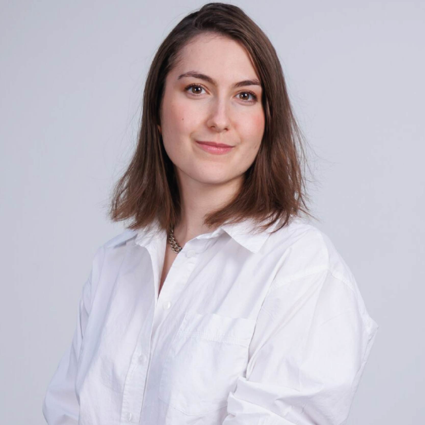 Portrait photo of Christiana Nika, PhD student, wearing a white shirt, with brown hair and a slight smile.