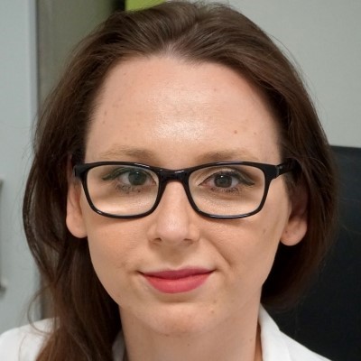 Portrait photo of Magdalena Witkowska, PhD student, with brown hair and black glasses.
